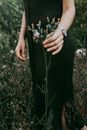 Woman Touching Flower Growing in Meadow