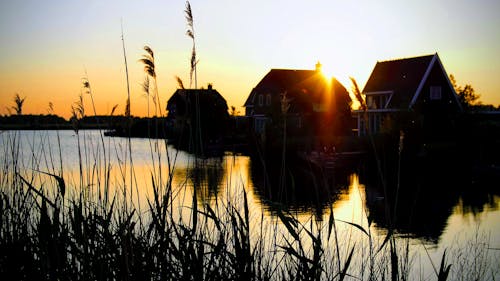 Silhouette Photograph of Houses Beside River