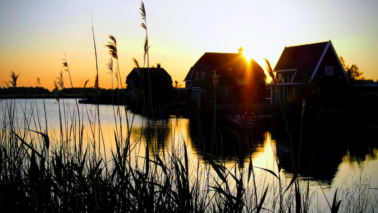 Silhouette Photograph of Houses Beside River