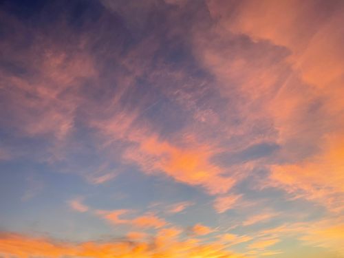 Free A stunning sunset sky with vibrant orange and pink clouds against a blue backdrop. Stock Photo