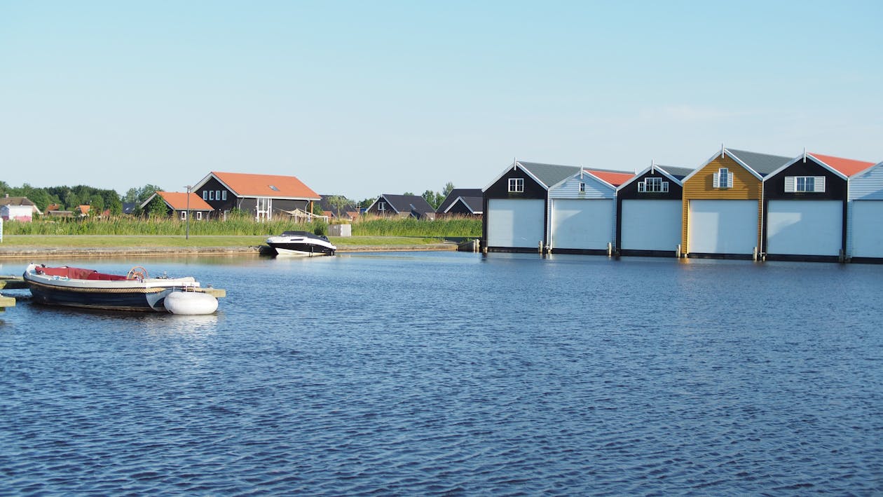 Bateau à Moteur Blanc Et Noir à Côté De L'herbe Verte