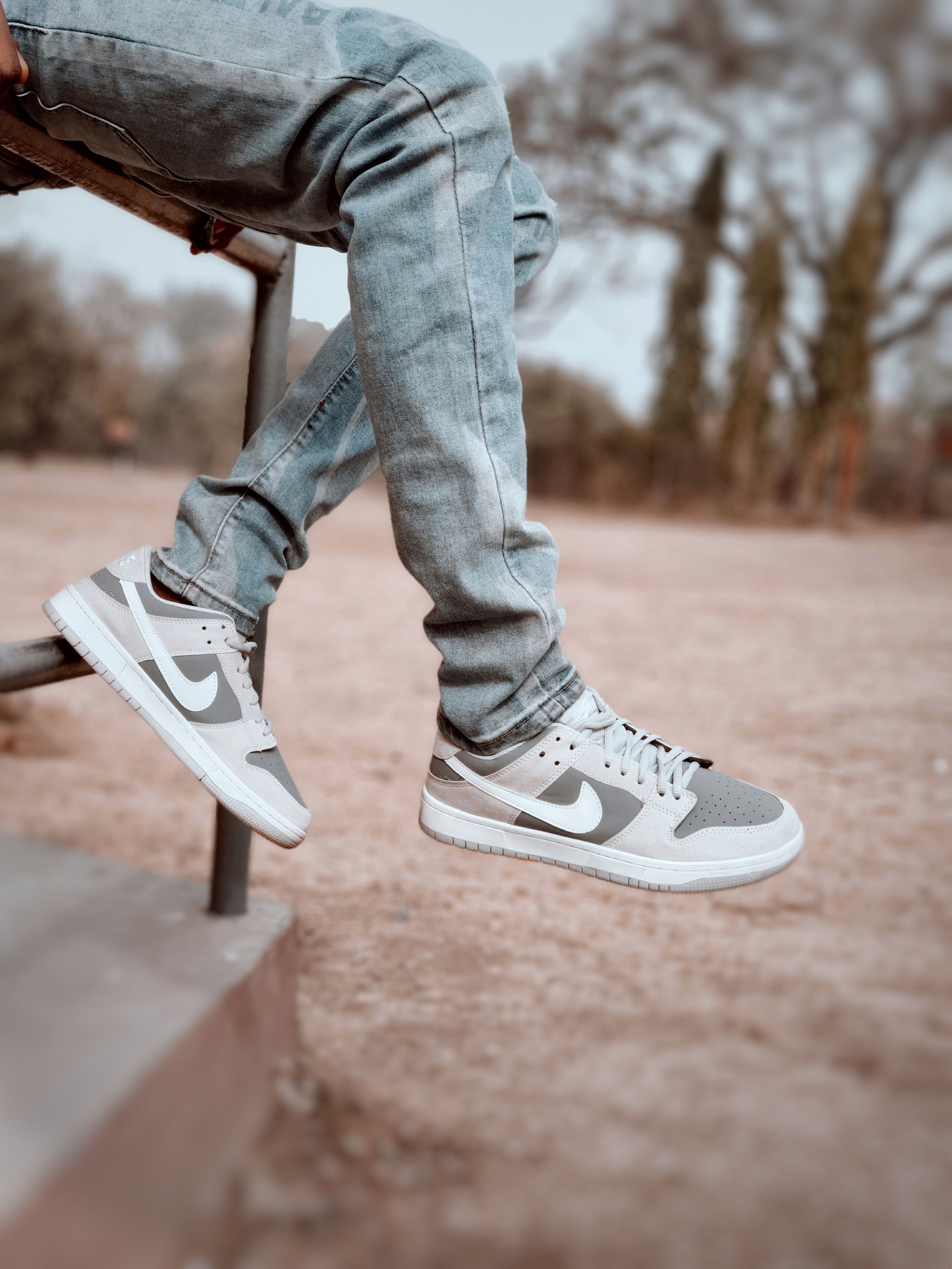 Casual outdoor fashion featuring denim jeans and sneakers on a sunny day.