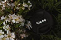 春天的花朵盛开，相机镜头盖周围环绕着它们，捕捉着大自然的美丽