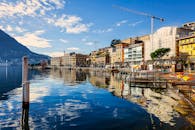 湖畔城市风景如画，建筑色彩缤纷，倒影在晴朗的天空下格外清晰