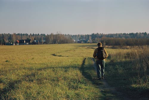 Back View of a Person Walking on the Field