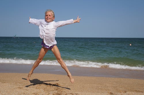 A Young Girl Jumping on the Beach 