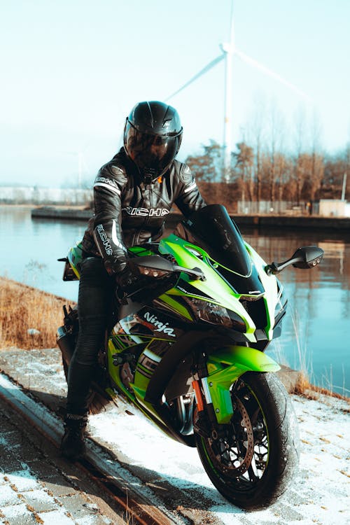 Free Man Riding a Green Motorcycle Stock Photo