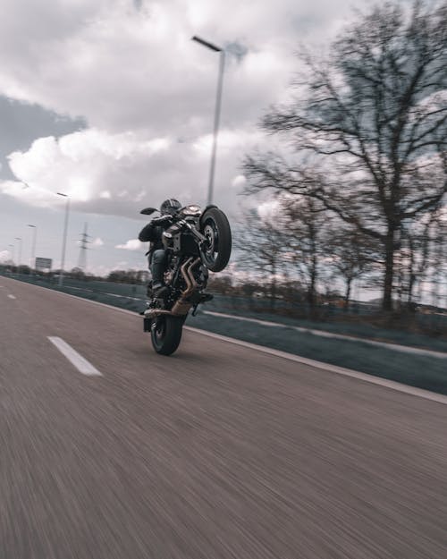 A Person Doing Wheelie using Motorcycle