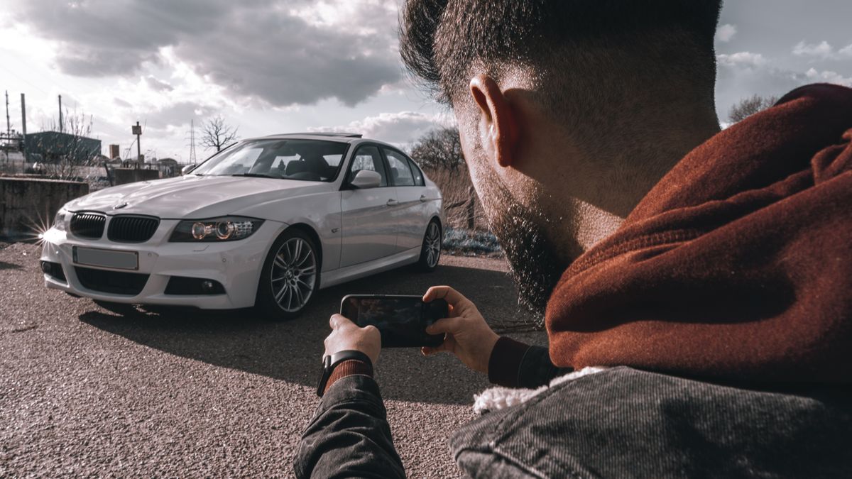 Person taking photos of an older vehicle with a phone