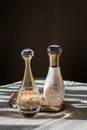 Two Clear Glass Bottles on White Textile