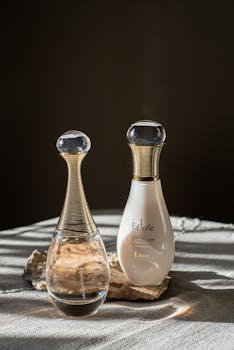 Minimalist still life featuring Dior J'adore perfume bottles with elegant design.