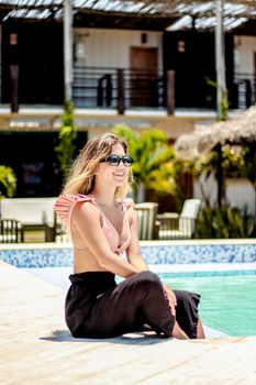 Young woman in sunglasses enjoying a sunny day by the pool in Adicora, Venezuela.