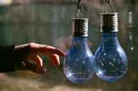 Person Holding Blue Glass Bottle