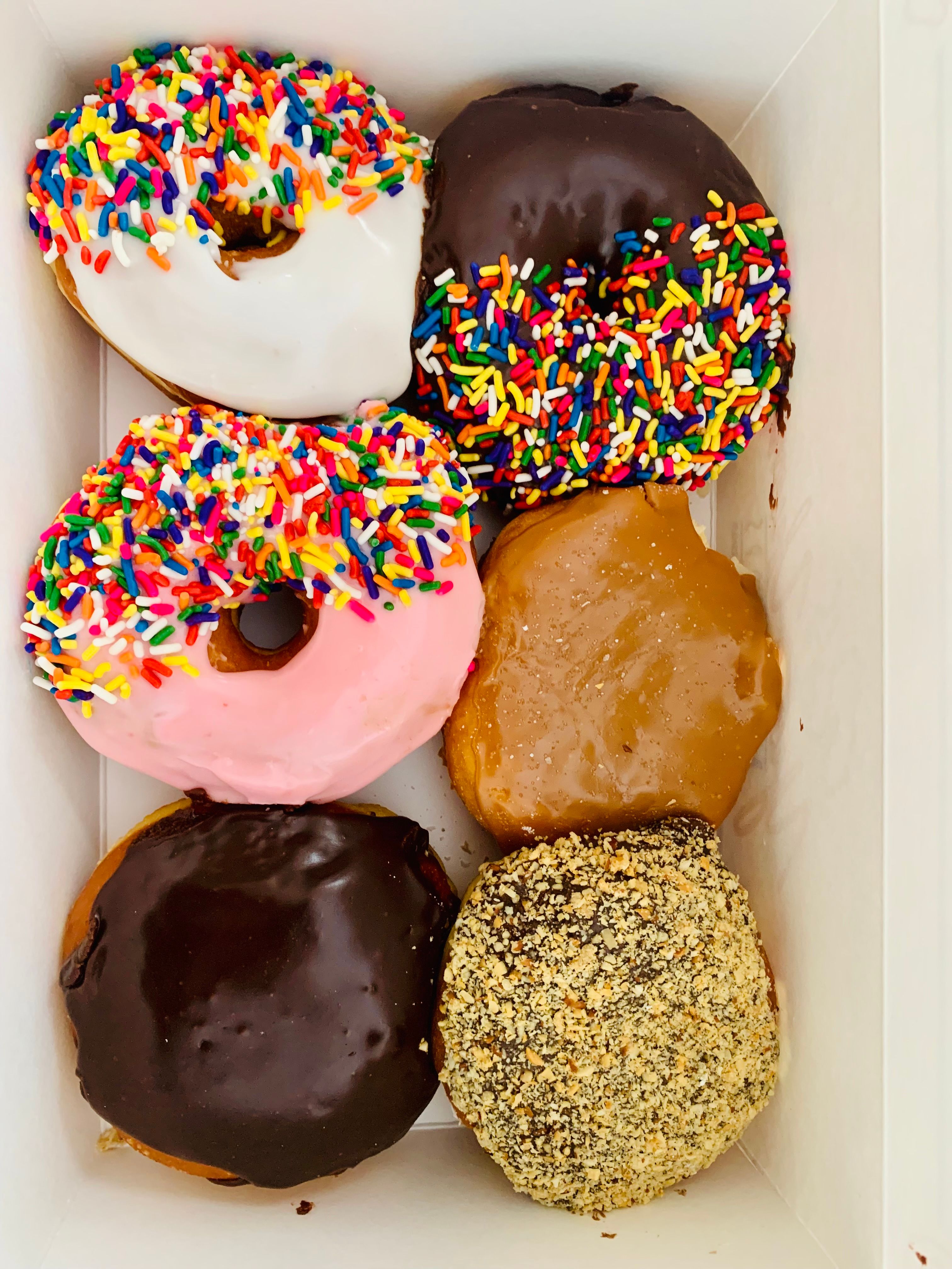 A box of assorted donuts covered with colorful sprinkles