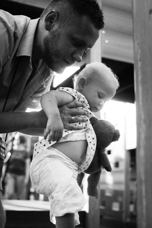 Free Monochrome Shot of a Father Carrying His Baby Stock Photo