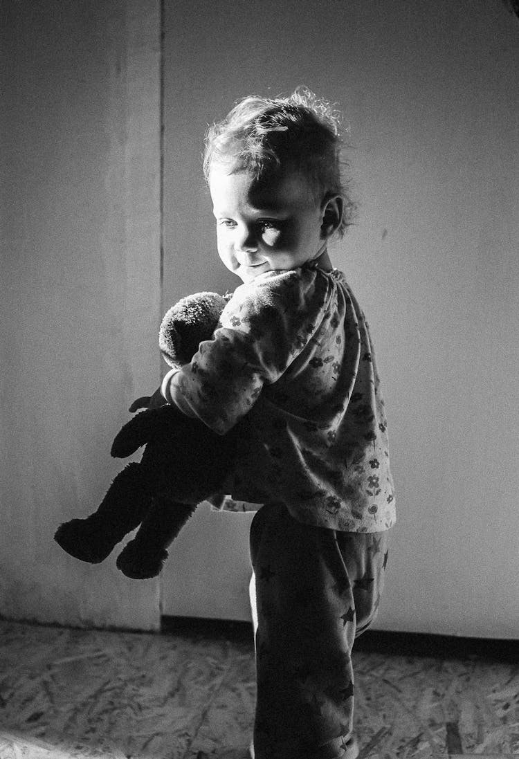 A Young Boy Holding A Teddy Bear