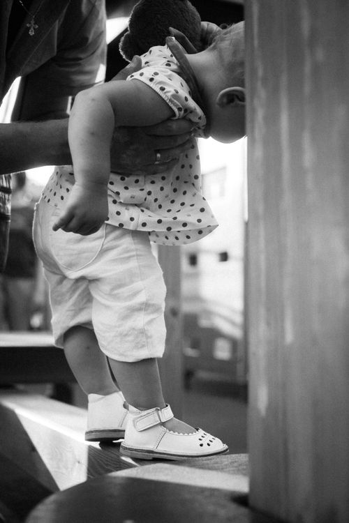 Free Touching black and white photo of a baby being gently supported by a parent's hands, embodying care and innocence. Stock Photo
