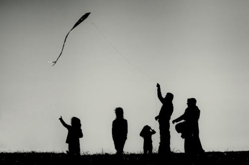 Silhouette of Family Watching the Kite