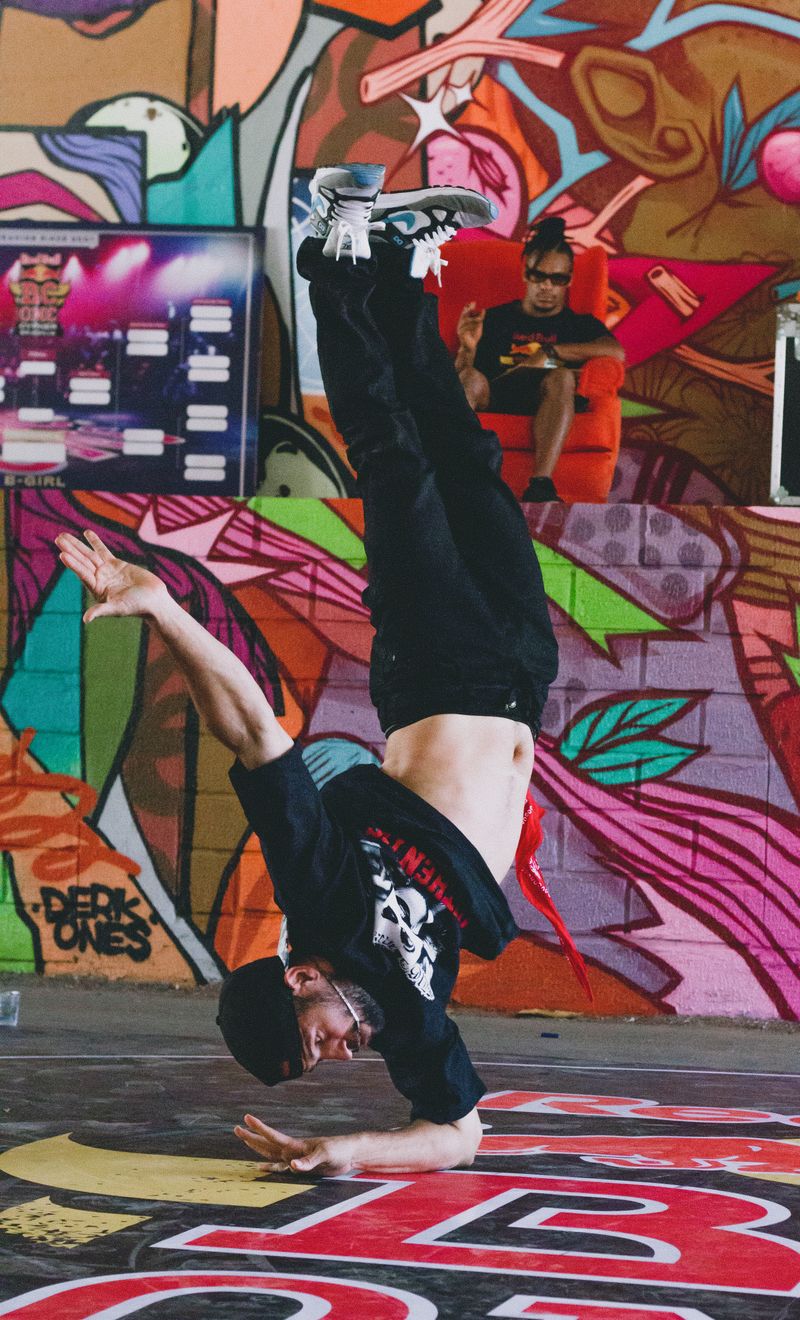Breakdancer freezing against a graffiti wall