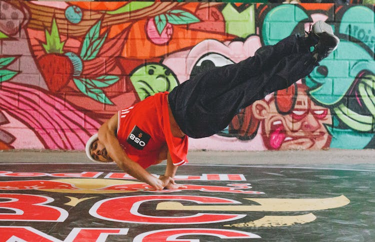 Man Breakdancing With Murals In The Background 