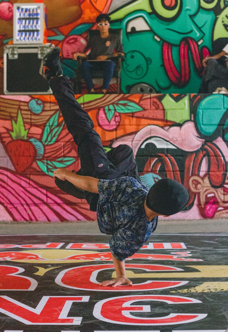  A Person Break Dancing Near A Wall With Mural