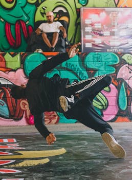 Energetic breakdancer performing moves in front of colorful graffiti. Perfect for urban and street culture themes.