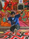 A Man in a Blue Shirt and Beanie Breakdancing