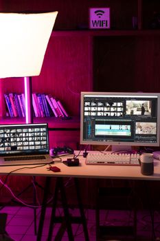 A modern home office setup featuring a laptop and dual monitors for video editing under soft lighting.