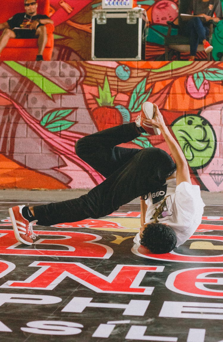 A Person In White Shirt And Black Pants Break Dancing