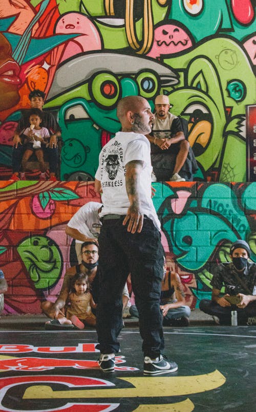 Free People Watching a Man Perform in a Building with Graffiti on Walls  Stock Photo