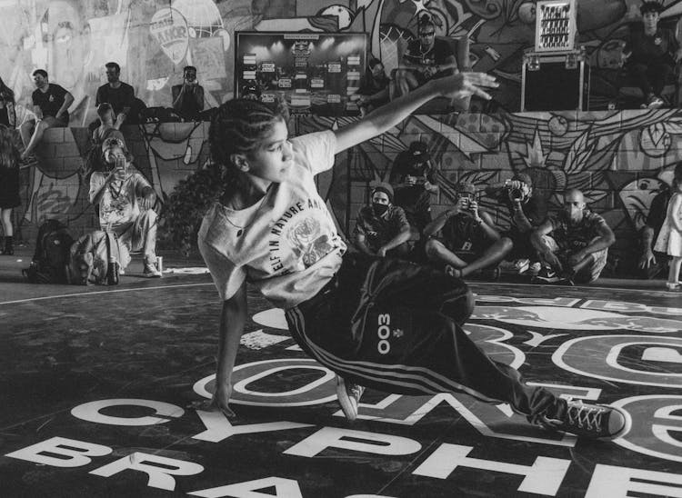 Grayscale Photo Of Woman Breakdancing On The Floor