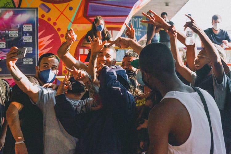 Group Of Young People Cheering And Taking A Selfie 