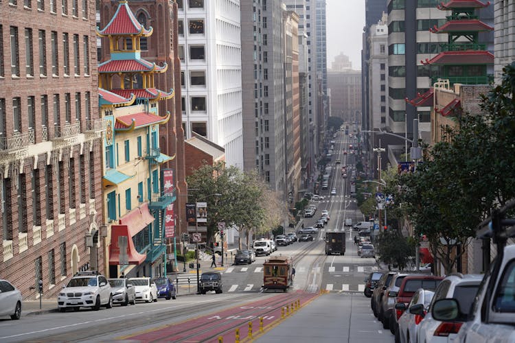 Tall Buildings And Parked Cars Along The Road