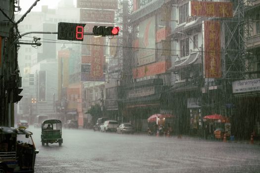 Rainy urban street scene with vehicles and vibrant city lights, capturing the essence of a bustling city under rainfall.