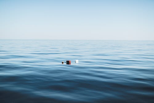 Three Red and White Floating Objects on Water