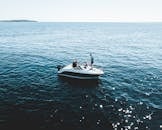 在明亮的日光下，摩托艇载着人们在平静的公海上巡航