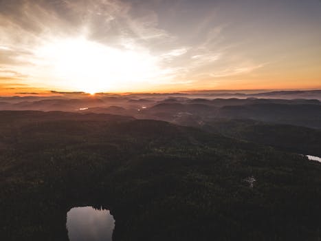 A breathtaking aerial view of hills and forests at sunrise, capturing the beauty of nature.