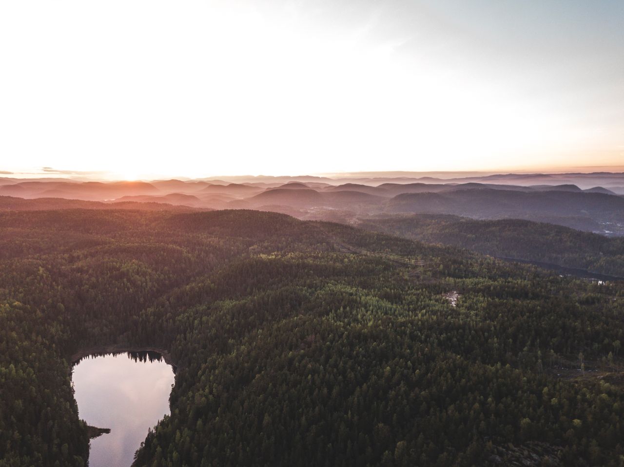 stunning aerial view capturing a serene misty forest with a reflecting