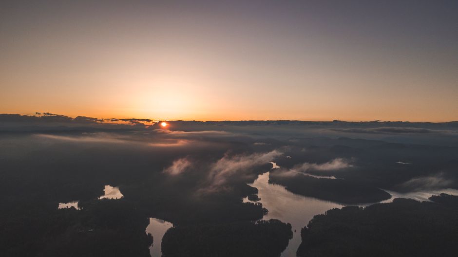 A breathtaking aerial shot capturing sunrise over a misty river with serene natural beauty.
