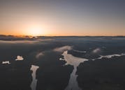 日出时分，蜿蜒的河流与云雾缭绕的宁静空中景观，展现了大自然的美丽