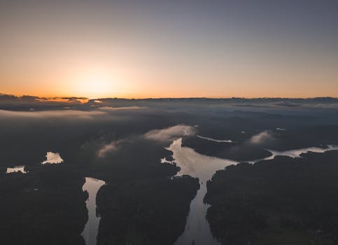 日出时分，河流蜿蜒，云雾缭绕，宁静的空中景观展现了大自然的美丽