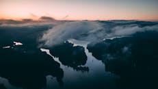 黎明时分，从空中俯瞰，宁静的河流与朦胧的风景映照着天空的色调，令人惊叹
