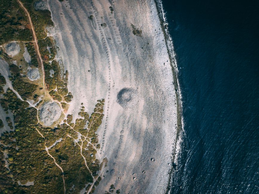 Stunning aerial shot capturing a rugged coastline's intricate patterns and rolling ocean waves.