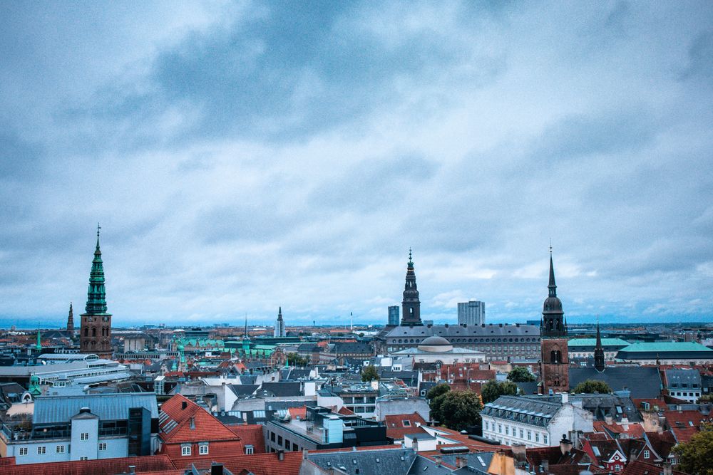 Wide-angle view of Copenhagen's historic architecture and skyline under overcast skies. Ideal for urban exploration them