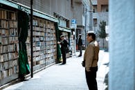 在繁忙的城市街道上，人们浏览户外图书展示，享受独特的购物体验