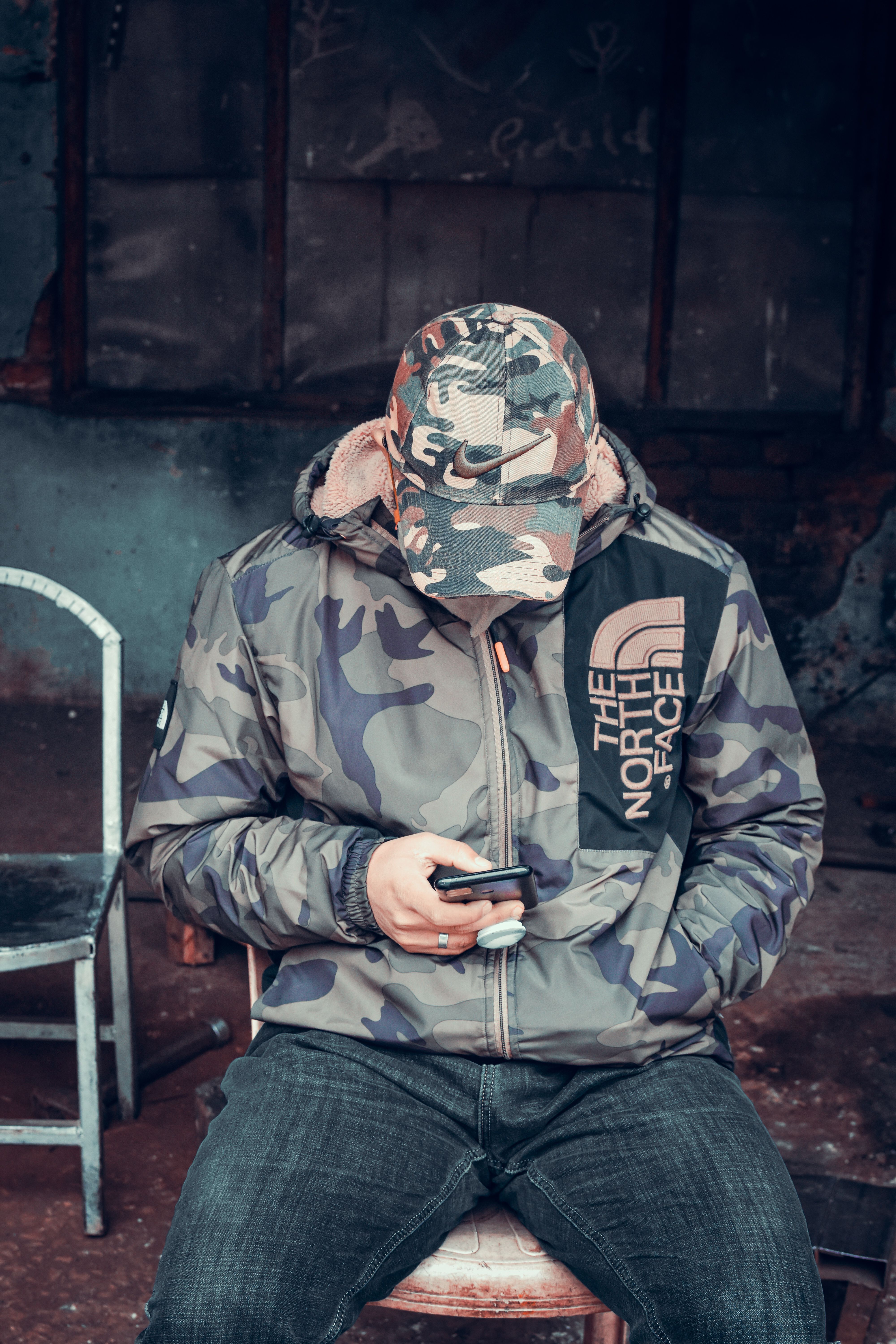 A Man Wearing Camouflage Jacket and Cap Using a Phone · Free Stock Photo