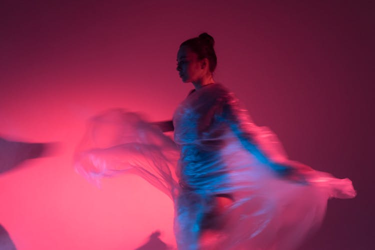 Woman In A Clear Dress Dancing In Pink Light