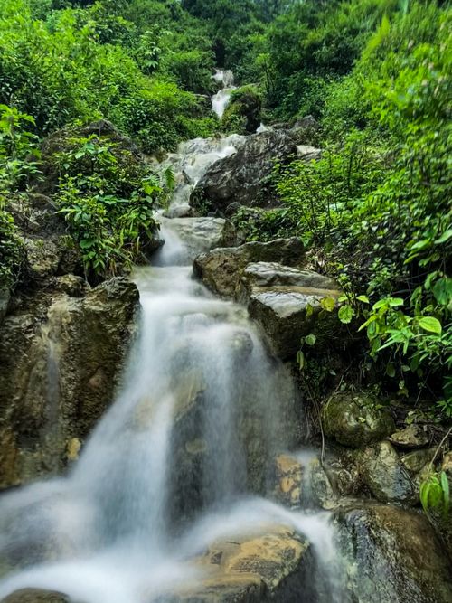 Free Experience the calming beauty of a tropical waterfall cascading through a verdant Indian forest. Stock Photo