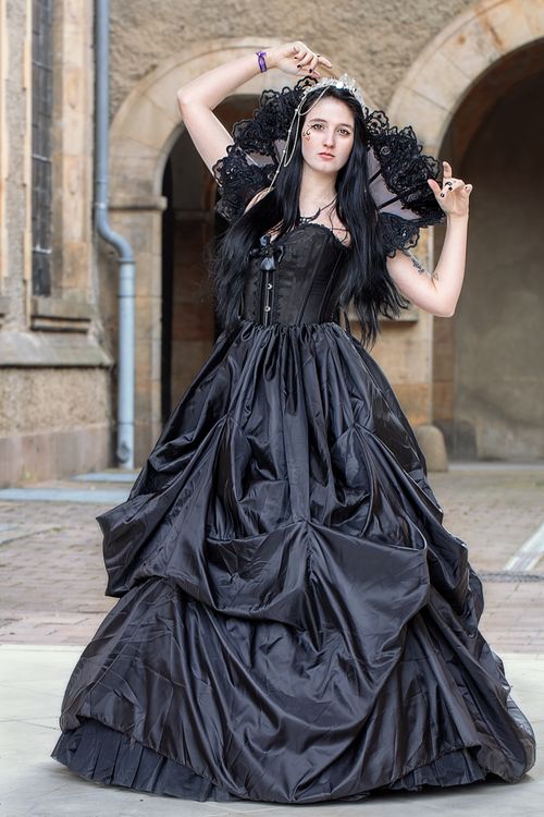 Free A graceful woman in a dramatic black gown posing outdoors in Leipzig, Germany. Stock Photo