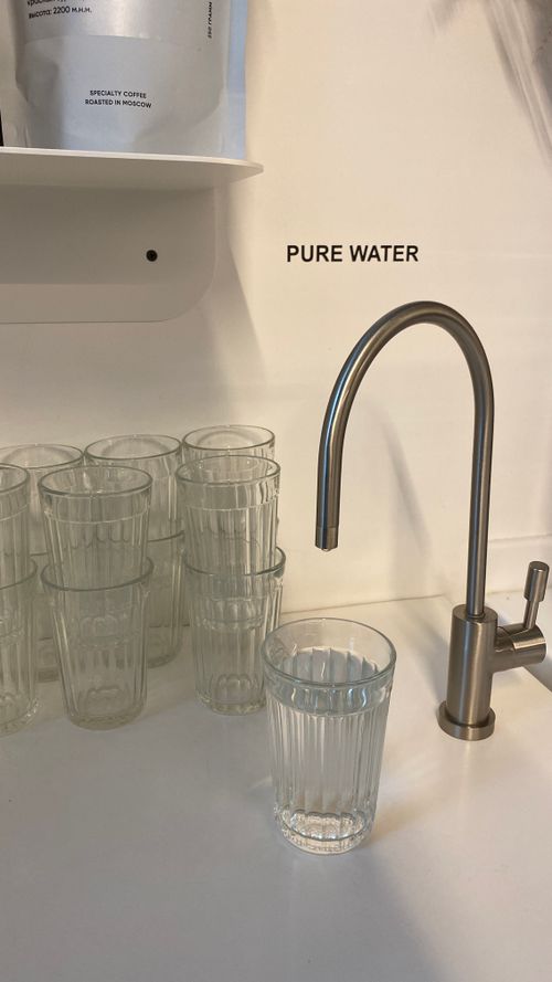 Free Clear glass under faucet with pure water label, indoor kitchen setting. Stock Photo